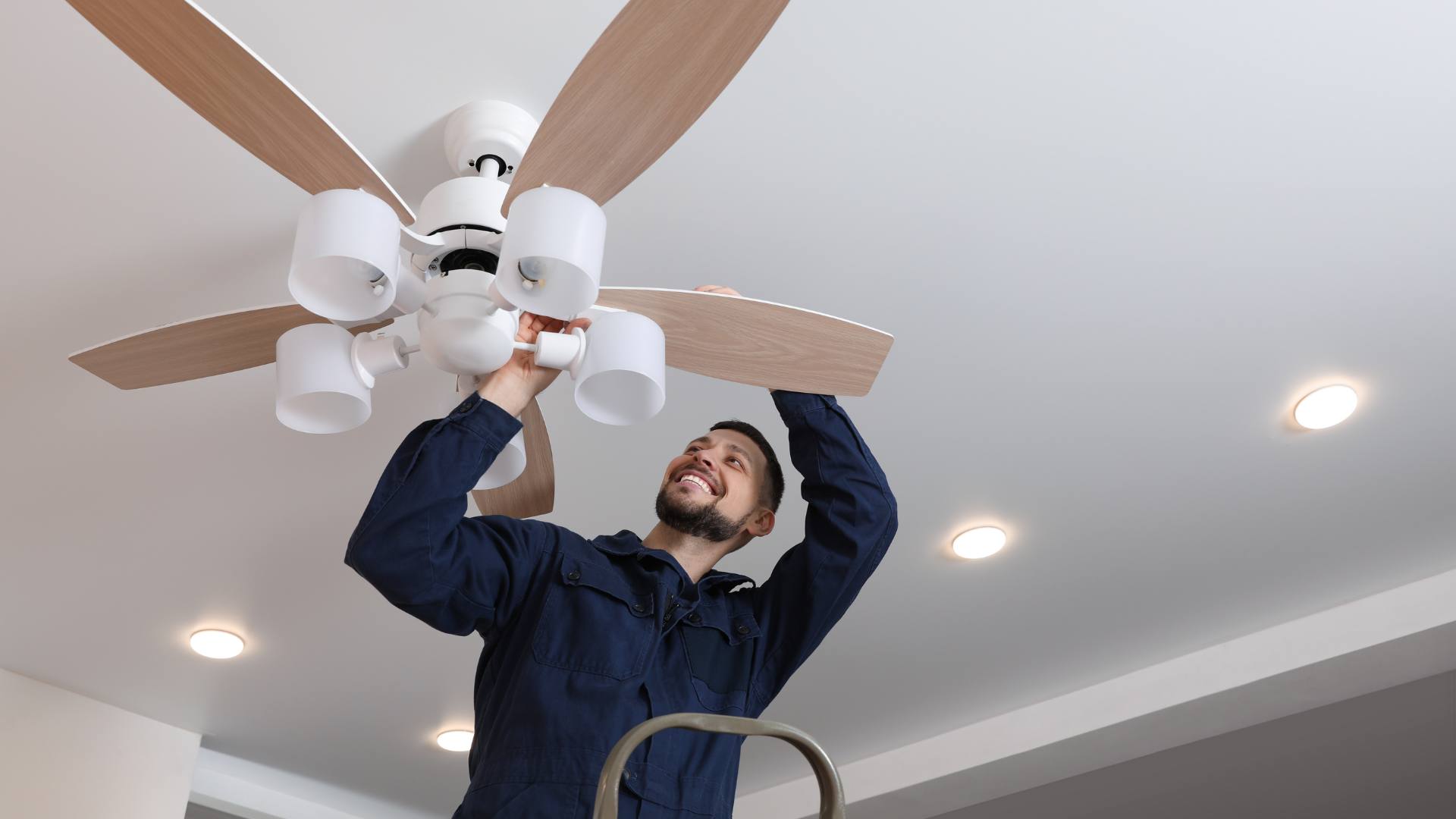 Electrician installing a ceiling fan